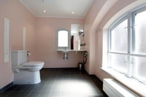 a bathroom with a toilet and a sink and a window at Hotel Bethel in Copenhagen