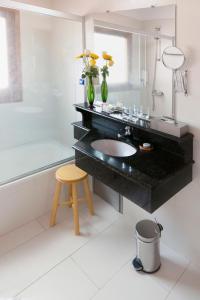 a bathroom with a black counter and a sink and a stool at Hotel Westfalenhaus in Asuncion