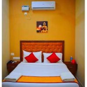 a bedroom with a large bed with red pillows at Villa Montecarlo in Puducherry