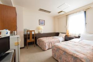 Habitación de hotel con 2 camas y escritorio en Suzuka Royal Hotel, en Suzuka