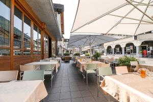 ein Restaurant mit Tischen und Stühlen in einem Gebäude in der Unterkunft Boutique Hotel Stanserhof in Stans