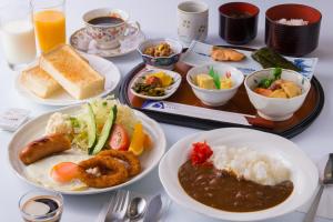 a table with plates of food and a tray of food at Suzuka Royal Hotel in Suzuka