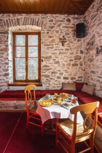uma sala de jantar com uma mesa com comida em Archontiko Montana em Vyzítsa