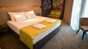 a hotel room with a bed with two towels on it at Hotel Olea in Novalja