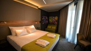 a hotel room with a bed with two towels on it at Hotel Olea in Novalja