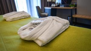a white blanket sitting on top of a bed at Hotel Olea in Novalja