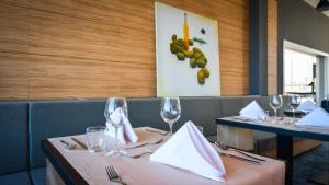 a dining room with two tables with wine glasses at Hotel Olea in Novalja