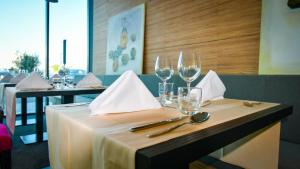 a table in a restaurant with wine glasses on it at Hotel Olea in Novalja