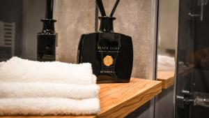 a bottle of black order on a wooden counter with two vases at Hotel Olea in Novalja