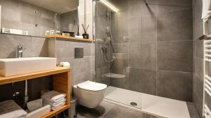 a bathroom with a shower and a toilet and a sink at Hotel Olea in Novalja