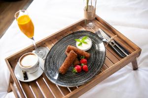 a tray with a plate of food and a cup of coffee at Teatro Suite & Rooms in Rijeka