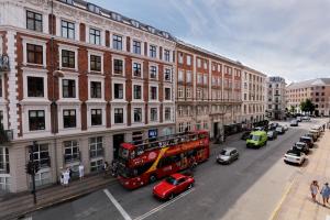 a red double decker bus driving down a city street at Hotel Bethel in Copenhagen