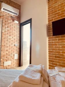 sypialnia z łóżkiem i ceglaną ścianą w obiekcie LoFT w mieście Bosa
