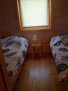 a small room with two beds and a window at Domki Monika in Sarbinowo