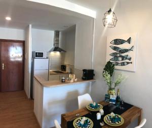 cocina y sala de estar con mesa y sillas en La Perla Apartment, en Torremolinos
