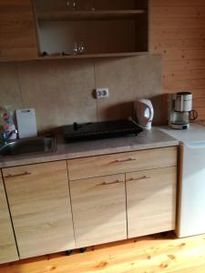 cocina con armarios de madera y encimera en Domki Monika, en Sarbinowo