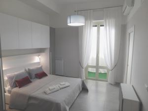 a white bedroom with a bed and a window at Palermo Relax in Palermo