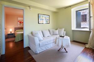 ein Wohnzimmer mit einem weißen Sofa und einem Tisch in der Unterkunft Apartments Casa Garibaldi in Brtonigla