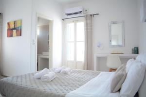 a white bedroom with towels on a bed at Maistrali in Provatas