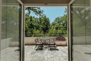 patio con mesa y sillas en el balcón en Poolside Apartments Miljan i Ranko, en Herceg-Novi