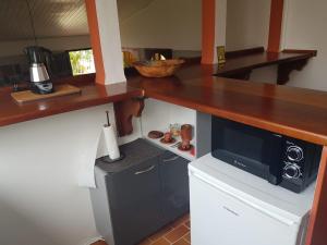 a kitchen with a counter top and a microwave at La DEPENDANCE CREOLE in Fort-de-France