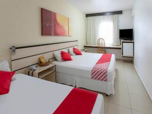 Habitación de hotel con 2 camas con almohadas rojas en Polo Hotel en São José dos Campos