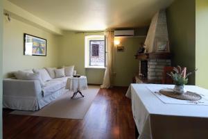 ein Wohnzimmer mit einer weißen Couch und einem Kamin in der Unterkunft Apartments Casa Garibaldi in Brtonigla