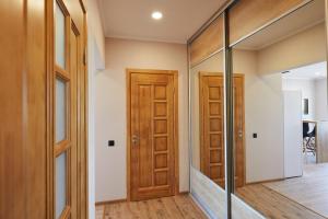 a hallway with wooden doors and a mirror at PaulMarie Apartments on Mayakovskogo in Minsk