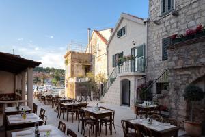 an outdoor patio with tables and chairs and buildings at Apt Bobotovi in center of Stari Grad, Hvar in Stari Grad
