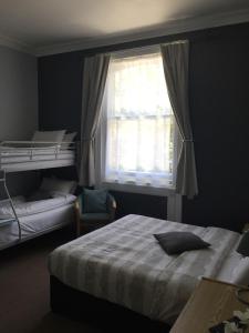 a bedroom with a bed and a window at Tregonholme Hotel in Bournemouth