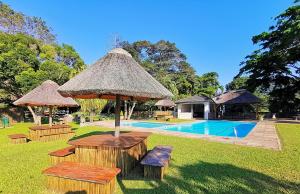 a resort with a table and chairs and a pool at Eden Wilds Unit 48 & 47 & 31 in Port Edward