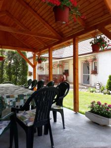 een patio met een tafel en stoelen onder een houten pergola bij Kaszivendégház in Hajdúszoboszló