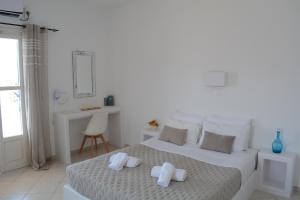 a white bedroom with a bed with towels on it at Maistrali in Provatas