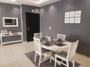a dining room with a white table and chairs at Second Home in Amman