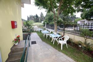 un patio con tavoli, sedie e recinzione di Pavlidis a Siviri