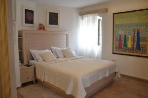 a bedroom with a bed with white sheets and a window at Apartmani Art Karampana in Kotor