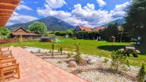 einen Garten mit Spielplatz und Berge im Hintergrund in der Unterkunft Apartmany Centrum in Pavčina Lehota