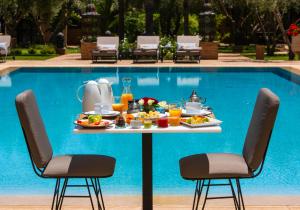 uma mesa de pequeno-almoço em frente a uma piscina em Riad Jawad & Spa em Marraquexe