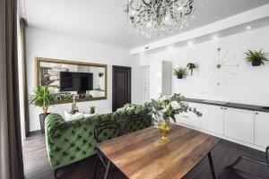 a living room with a table and a green couch at Four Luxury flats in Kaunas