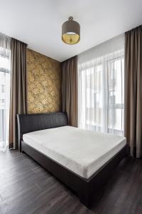 a bedroom with a large bed in front of a window at Four Luxury flats in Kaunas