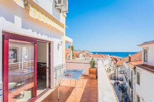 a balcony with a table and a view of the ocean at Estrela de Sesimbra in Sesimbra
