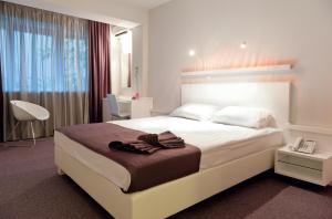 Un pat sau paturi într-o cameră la Leonardo Hotel
