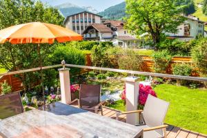 a patio with a table and chairs and an umbrella at Achen Villa in Bad Hofgastein