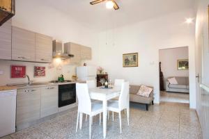 a kitchen with a table and white chairs in it at Dimora Ricceri in Impruneta
