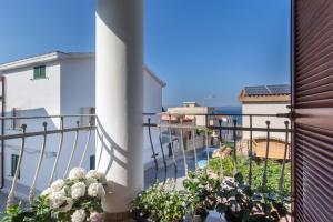 a balcony with plants and a view of the ocean at Stella Moresca Luxury Villa in Calasetta