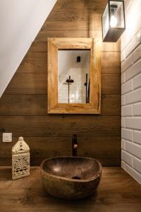 W łazience znajduje się kamienna umywalka i lustro. w obiekcie Gotyk House w Gdańsku