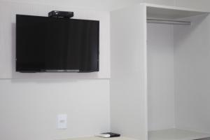Elle comprend une télévision à écran plat suspendue sur un mur blanc. dans l'établissement Xingu Praia Hotel, à Altamira