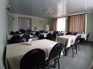 a conference room with tables and chairs and a screen at TimGiz in Ureki