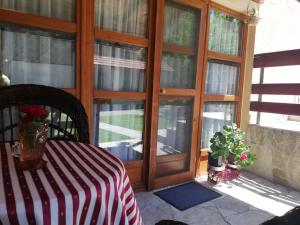 a screened in porch with a table and glass doors at Apartments Šćepanović in Kolašin