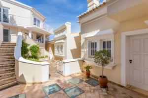 um pátio de uma casa com uma porta branca em Top Cliff Villa with ocean view and pool at stunning cliffs no Burgau